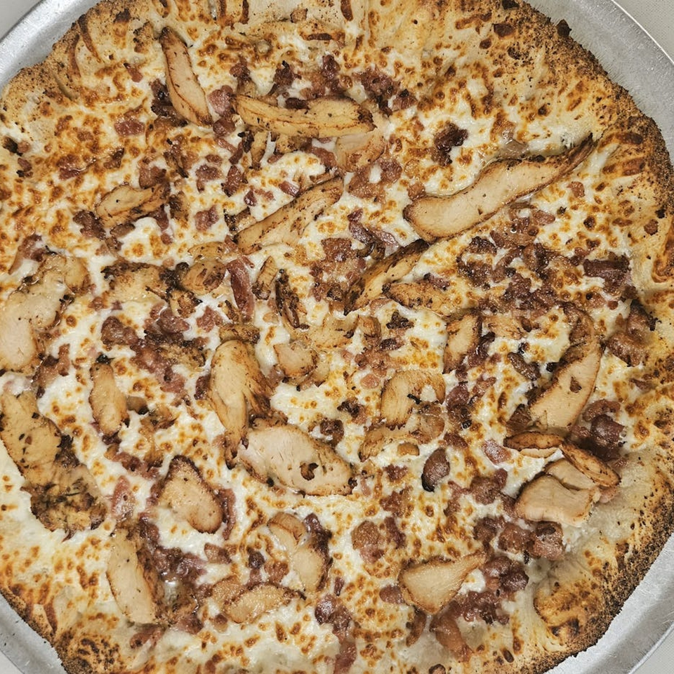 Pizzano's Pizza & Grinders' chicken and bacon pizza with a white sauce base.